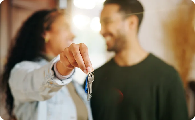 Imagem de um casal segurando uma chave